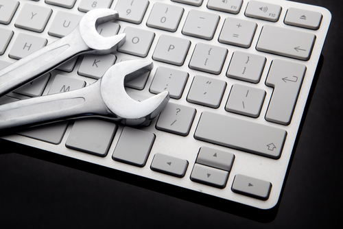 Two wrenches laying on a computer keyboard